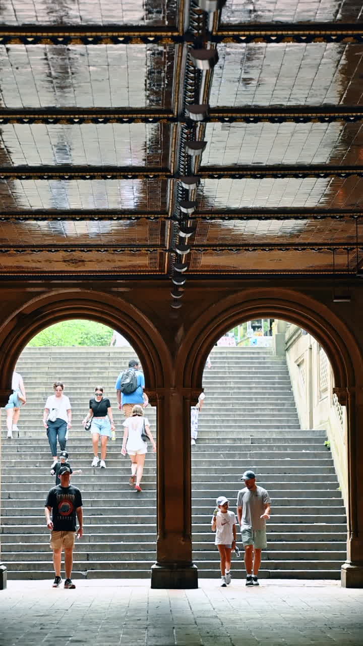 New York, USA, 8 novembre 2025: iconico porticato della Bethesda Terrace a Central Park con turisti sulle scale. Il soffitto decorato con piastrelle Minton incornicia gli archi storici che conducono alla Bethesda Fountain.