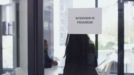 a woman entering the boardroom for her interview