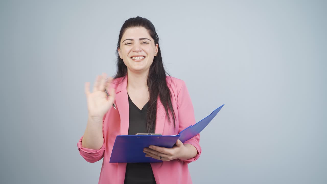 mujer de negocios saludando a la cámara.