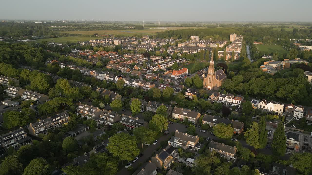 Top-down view of a European village square with a prominent old church at the center, surrounded by homes.