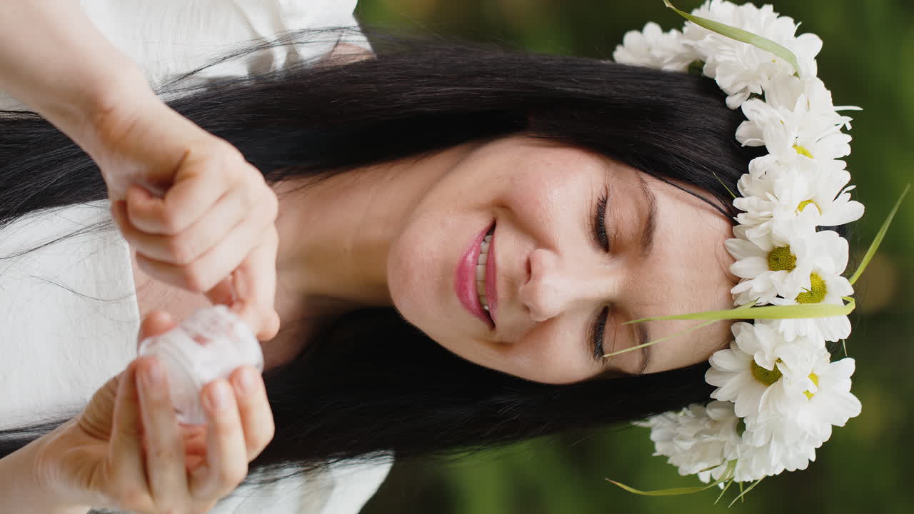 건강한 40대 성숙한 중년 여성이 얼굴 피부에 보습 크림을 적용합니다.