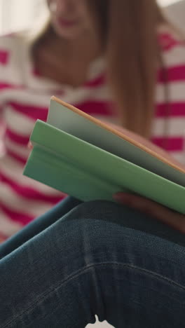 mujer lee un libro sentada en el piso de primer plano. el lector da la vuelta a las páginas aprendiendo el tema con su amiga en la biblioteca. estudiante universitario con el libro de texto en el interior