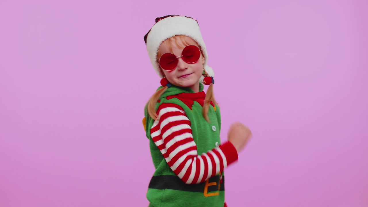 Dívka, vánoční skřítek Santa Clause, poslouchá hudbu přes sluchátka, tančí disko, blbne a baví se