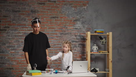 el pequeño estudiante hace pruebas con líquidos bajo el control del tutor