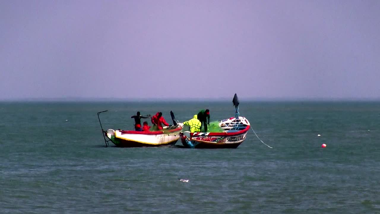African Fishermen pulling in their nets at the end of a long day, close to shore.