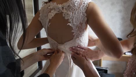 bride getting ready in wedding dress with bridesmaids