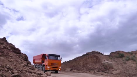 orange dump truck on a dirt road