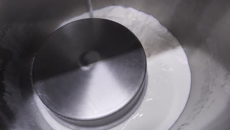 inside steel vat, filling factory cauldron with milk for pasteurization process