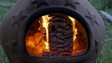 slo-mo: brasas ardientes en una chimenea de terracota durante la noche