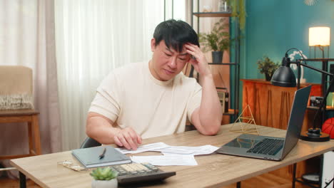 asian man throwing bills onto table after shocking amount eyebrows raised very frustrated reaction