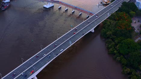 aerial view of vehicles driving at pacific motorway bridge at sunset in brisbane city, queensland, australia