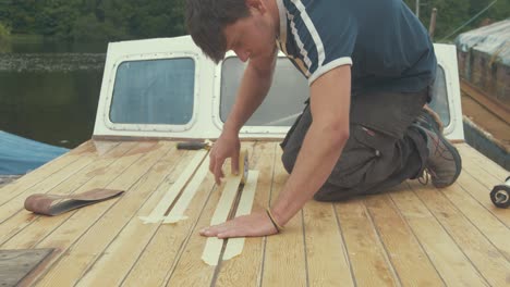 a young masking tape before apply waterproof sealant between planks