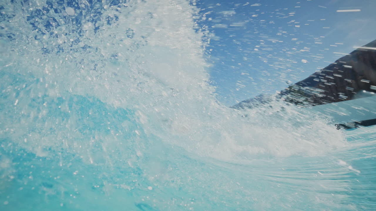 Surf de alto rendimiento en una moderna piscina de olas en un día soleado con agua cristalina. Giros potentes, tubos y rociones enmarcados por los Alpes suizos, creando un entorno de surf alpino único.