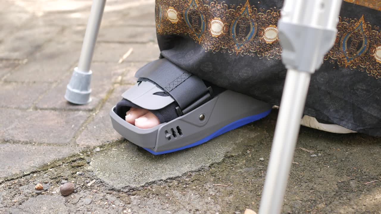 pie lesionado con muletas y botas para caminar