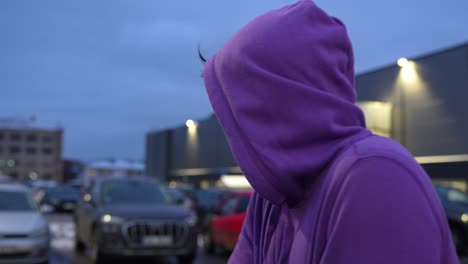 guy rubbing his hands on his shoulders due to cold weather while at the parking lot, dynamic closeup