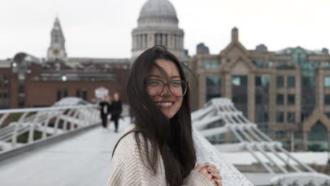 Happy-smiling-tourist-woman-stood-on-Millennium-Bridge,-London-in-front-of-St-Pauls-Cathedral
