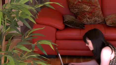 mujer animada usando una computadora portátil acostada en el suelo