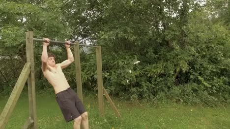 young athletic man doing explosive pullups on outdoor home gym