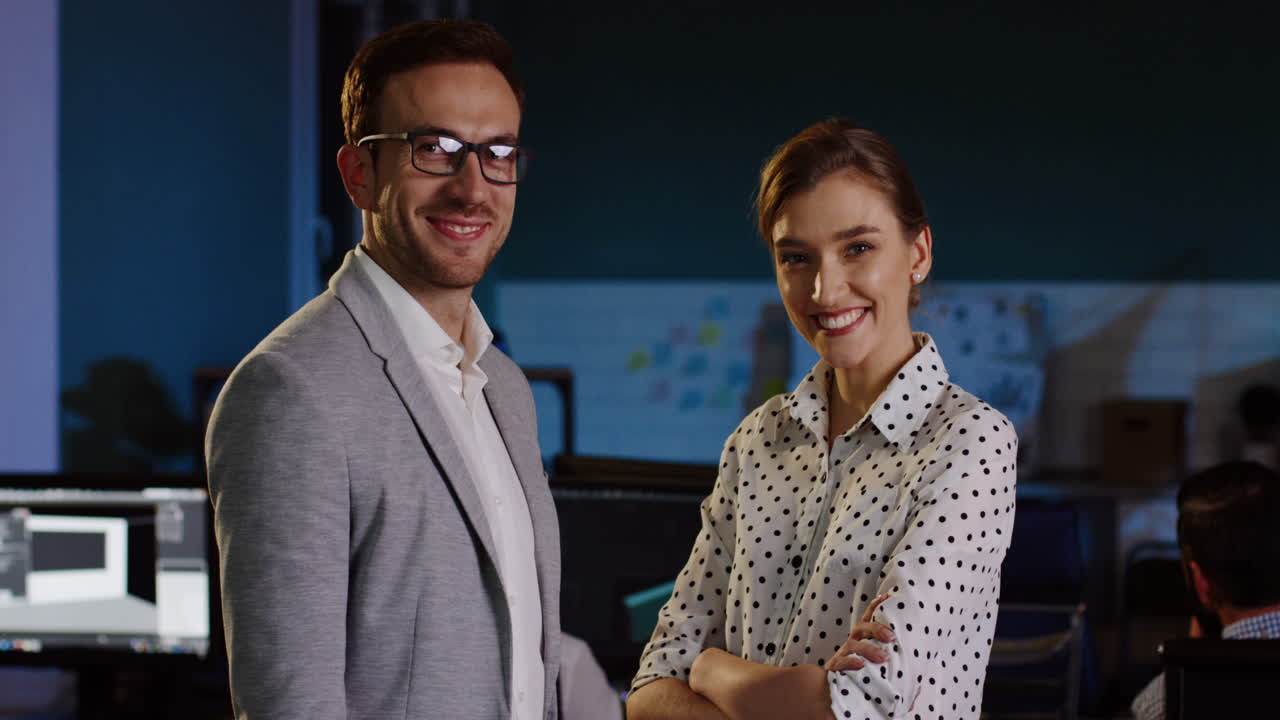 retrato de un hombre de negocios y una mujer de negocios mirando y sonriendo a la cámara en la oficina