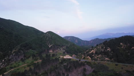 Traveling-California-mountain-roads-at-sunset,-aerial-view