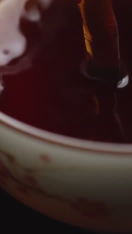 vertiendo té en una taza pequeña