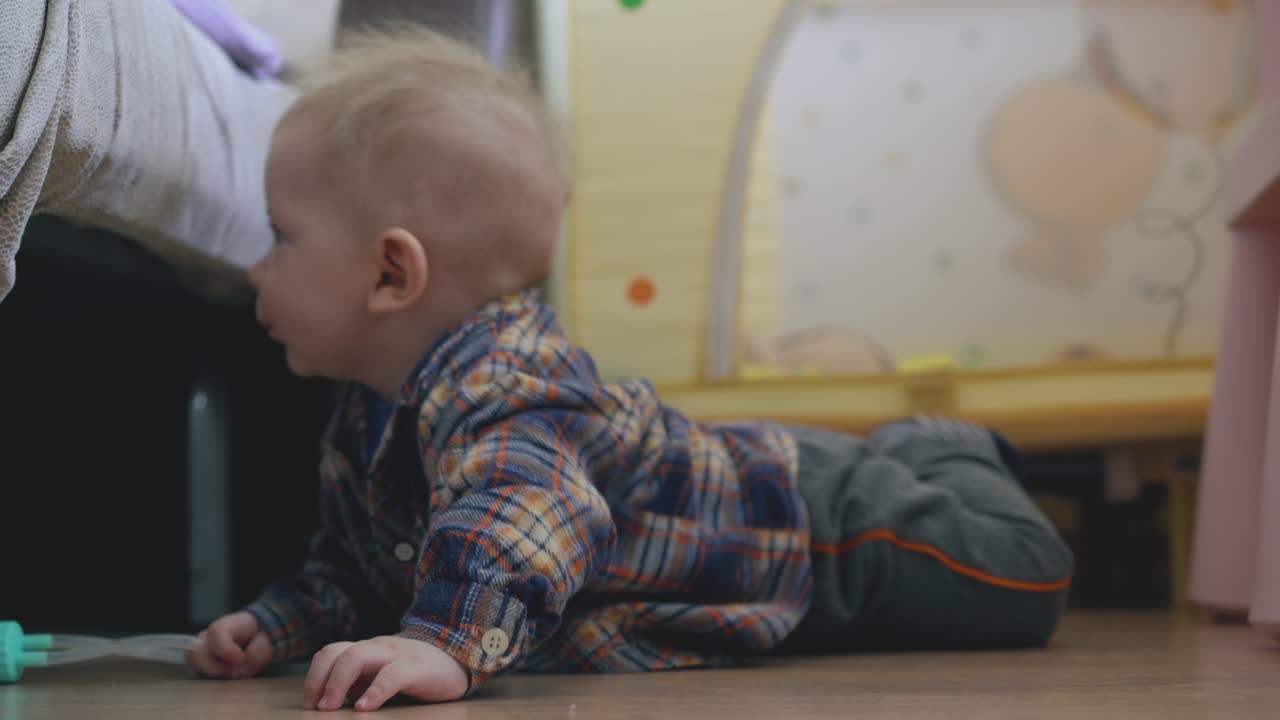 un niño gracioso garabatea y se apoya en una cama suave en el suelo de madera