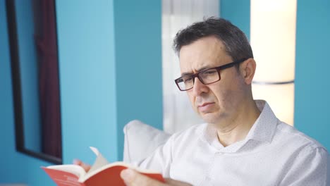 man carefully reading a book.