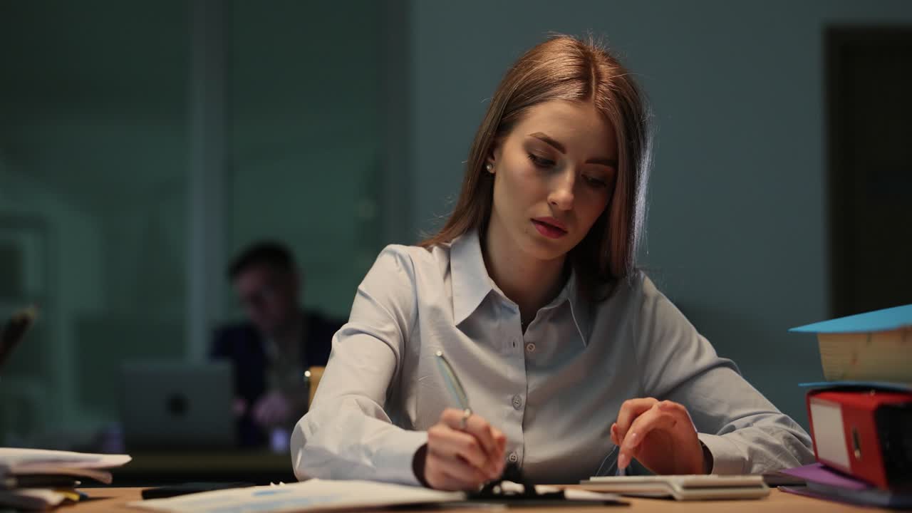 Jovem Empresária Focada Trabalhando Até Tarde no Escritório com Calculadora e Caderno