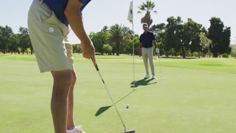 Dos-Hombres-Mayores-Caucásicos-Practicando-Golf-En-El-Campo-De-Golf-En-Un-Día-Soleado