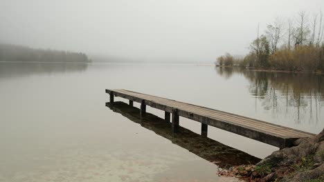 A-pier-leading-out-to-a-lake-on-a-moody-and-minimalist-day-at-Lake-Bohinj