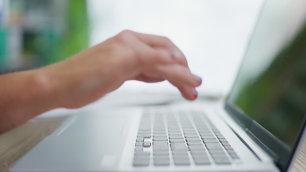 mujer escribiendo en una computadora portátil en la oficina close-up de las manos