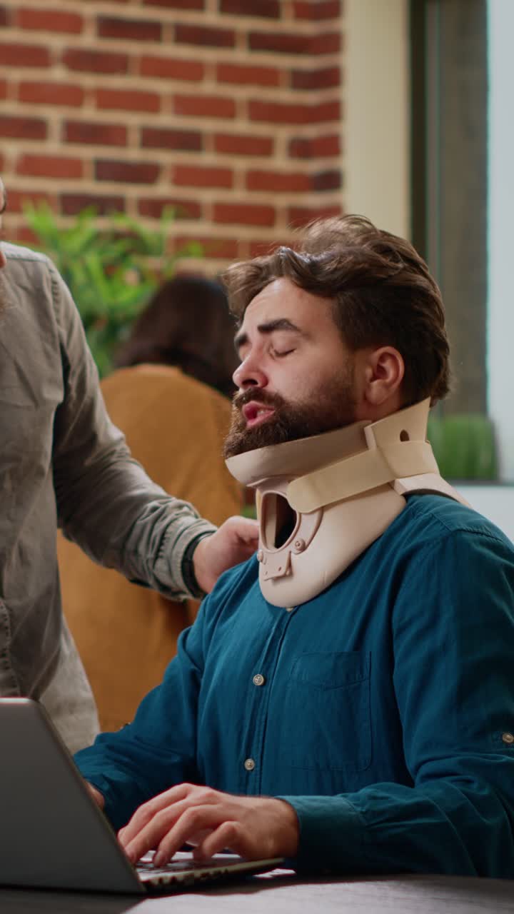Man with Neck Brace Working on Laptop