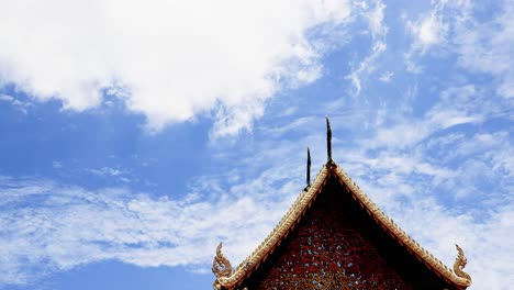 Lapso-De-Tiempo-De-Cielo-Azul-Con-Nubes-Blancas-Sobre-El-Gran-Salón-O-Vihara-Luang-Que-Está-Decorado-Con-Madera-Dorada-En-Wat-Phra-That-Hariphunchai-En-La-Provincia-De-Lamphun-De-Tailandia