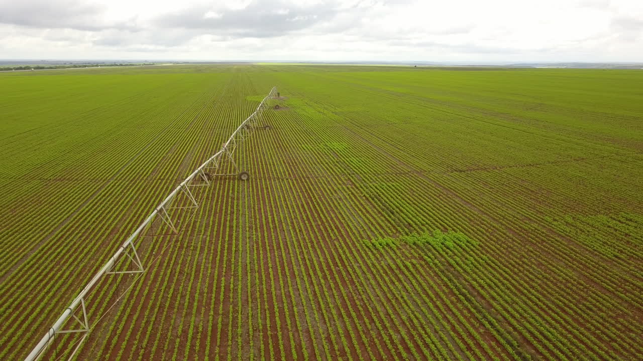 volando sobre un campo de cultivo en américa del sur con un largo sistema de riego que atraviesa el campo