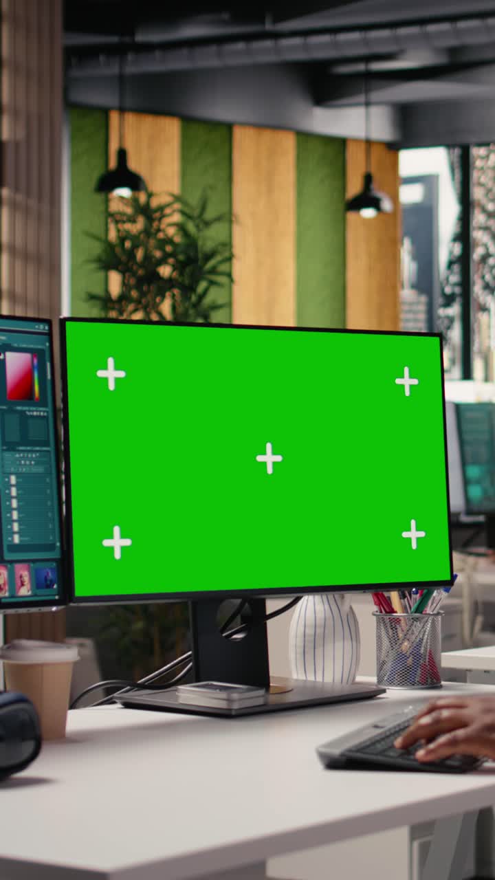 Monitor green screen per video verticale accanto a software di editing per foto di cataloghi commerciali.