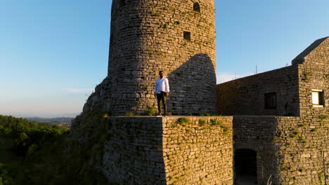 hombre de pie en el castillo de srebrenik contra el cielo azul cerca de la ciudad de sreblenik en bosnia y herzegovina