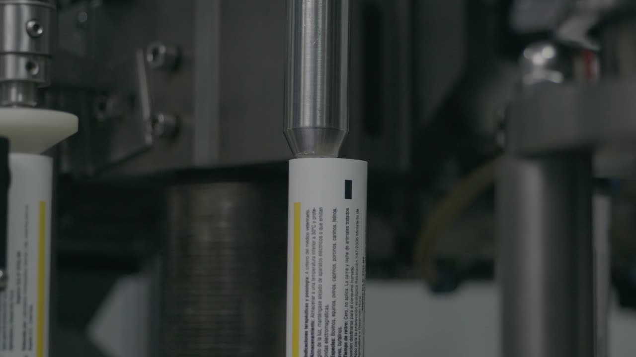 Production and alignment of metal tubes to be filled with tablets, forming the final packaging for efficient and precise medication distribution.