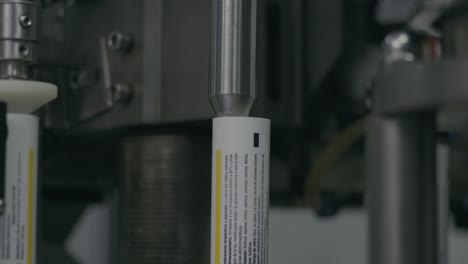 production and alignment of metal tubes to be filled with tablets, forming the final packaging for efficient and precise medication distribution.