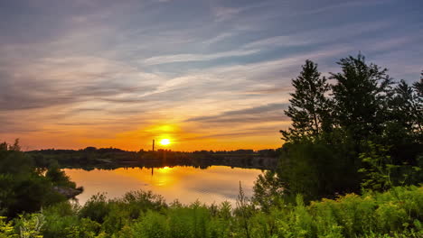 Golden-sun-reflecting-on-lake-surface-during-beautiful-golden-sunset-in-the-evening---Panorama-time-lapse-in-wonderful-wilderness