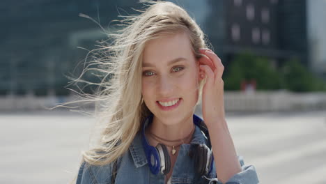 portrait beautiful young blonde woman smiling running hand through hair enjoying relaxed urban day in city slow motion feminine beauty