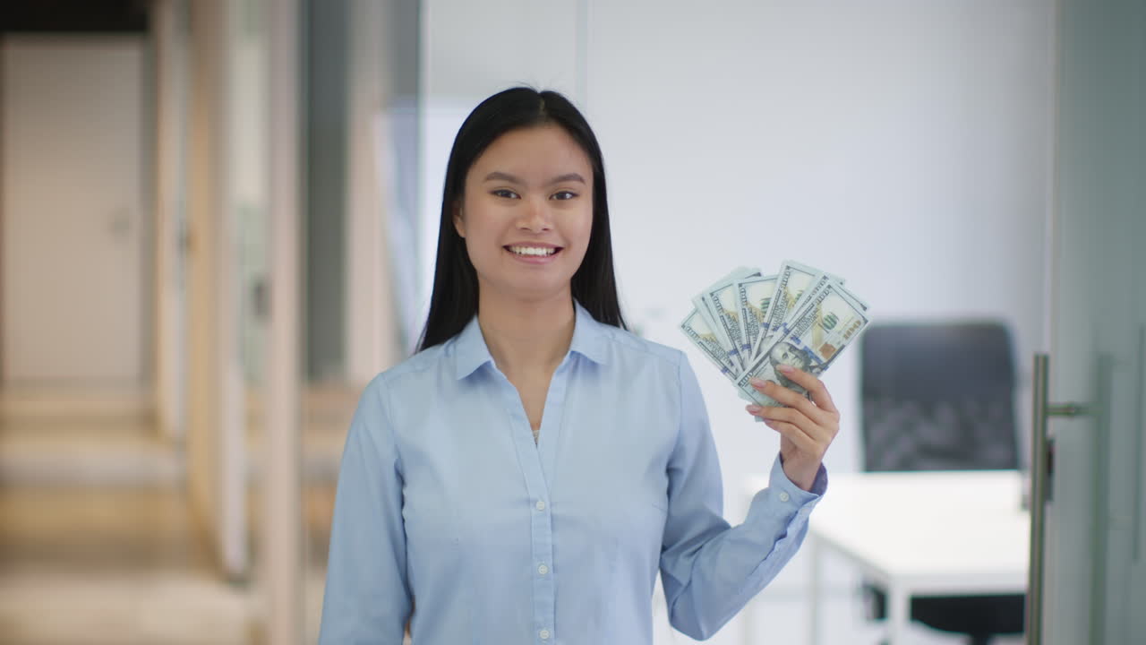 Woman holding US dollars in an office