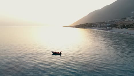 small water boat tied near the shore during sunset close to the beach and mountains