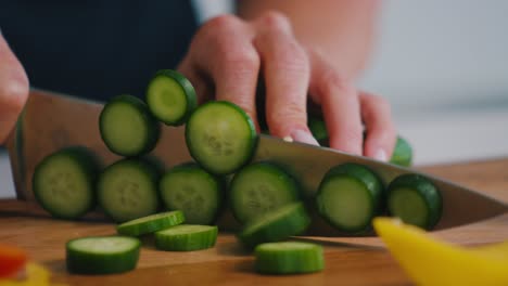 화창한 날 부엌에서 야채 오이를 자르는 사람