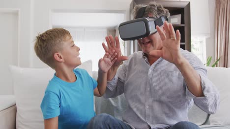 senior man wearing a virtual reality headset with her grandson