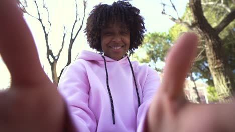 Cheerful-black-man-with-dreadlocks-and-camera-in-hands