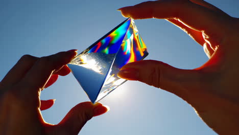 hand holding a prism refracting light