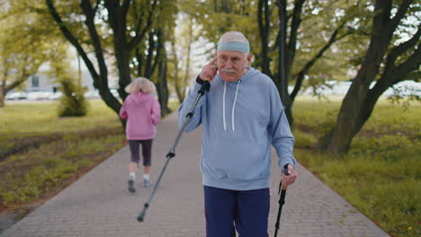 Anciano-Jubilado-Sano-Abuelo-Entrenando-Marcha-Nórdica-Uso-De-Bastones-De-Esquí-En-El-Parque-De-Verano