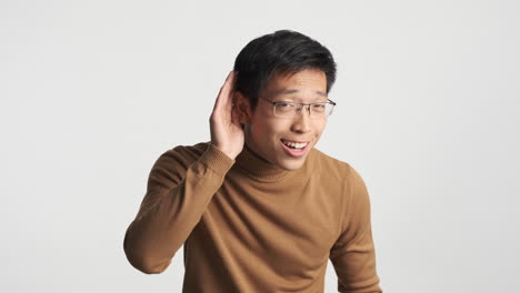 Asian man showing I don&#039;t hear expression.
