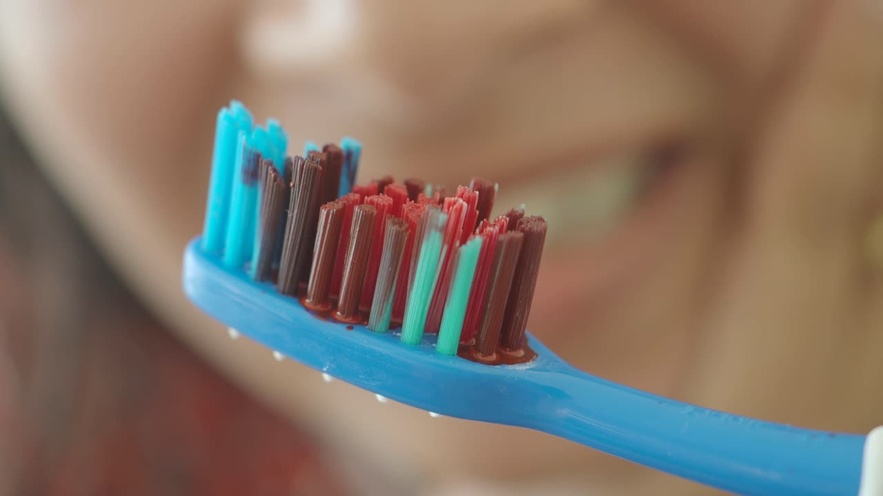 Close-up of a used toothbrush with colored bristles