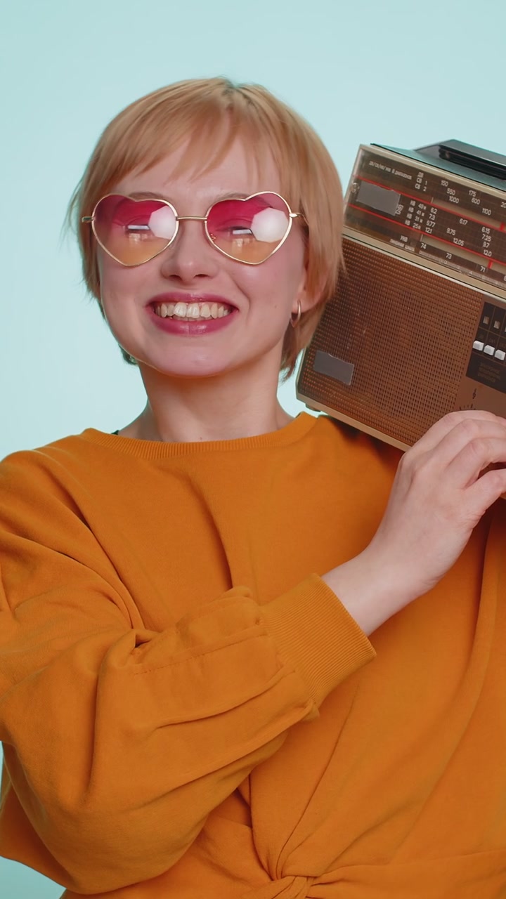 Donna che usa un giradischi retro per ascoltare musica disco ballando la sua canzone preferita divertendosi